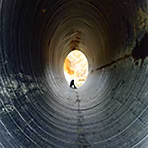 depressed young man sitting in the drain